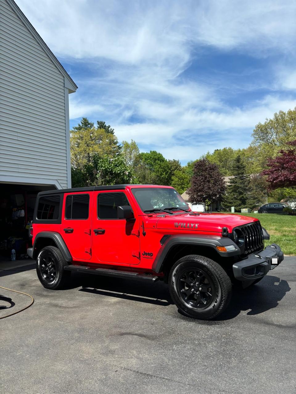 A red Jeep Wrangler Willys, glossy after a hand wash