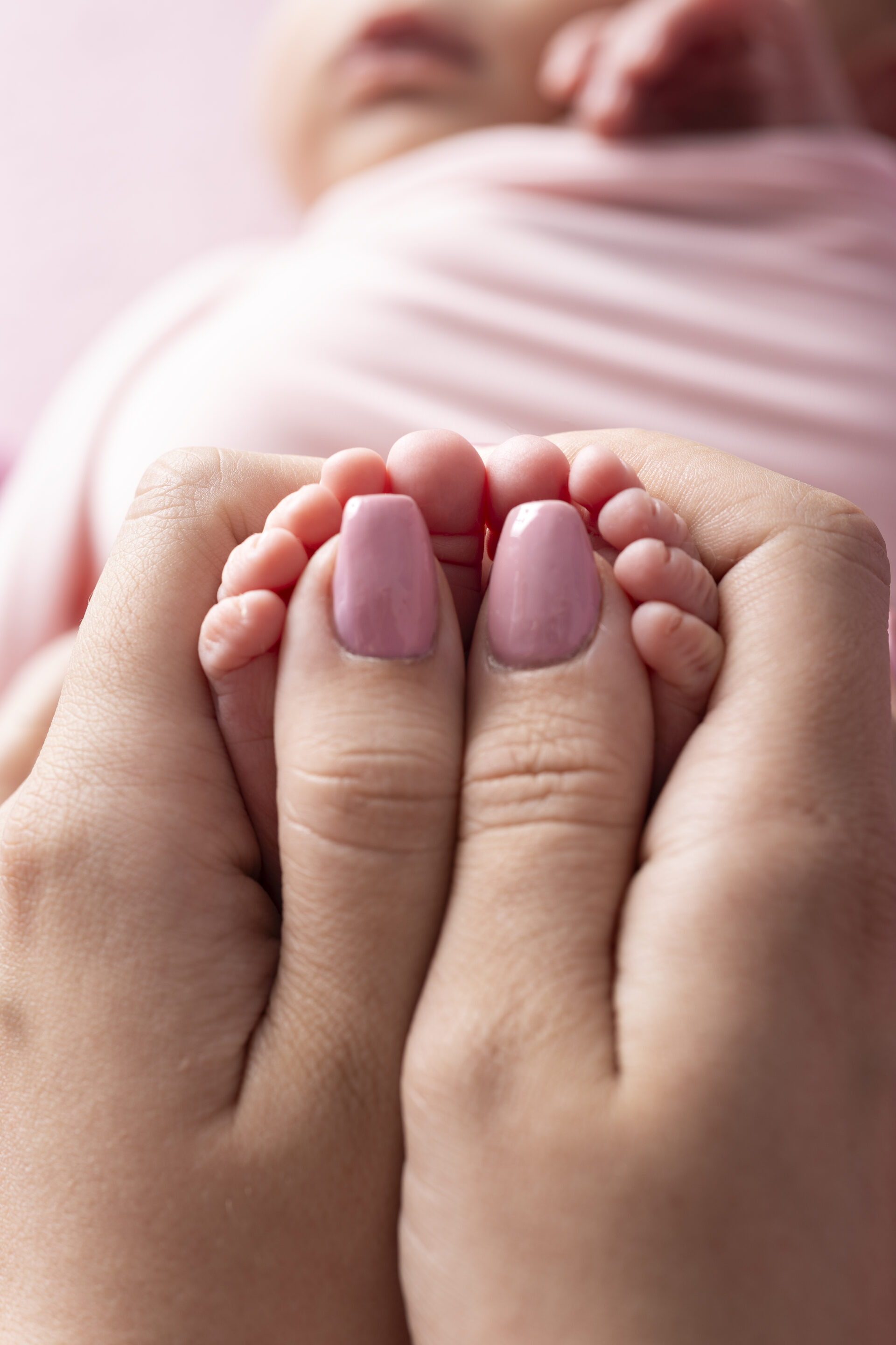 Winzige Babyfüße in Mamas Händen