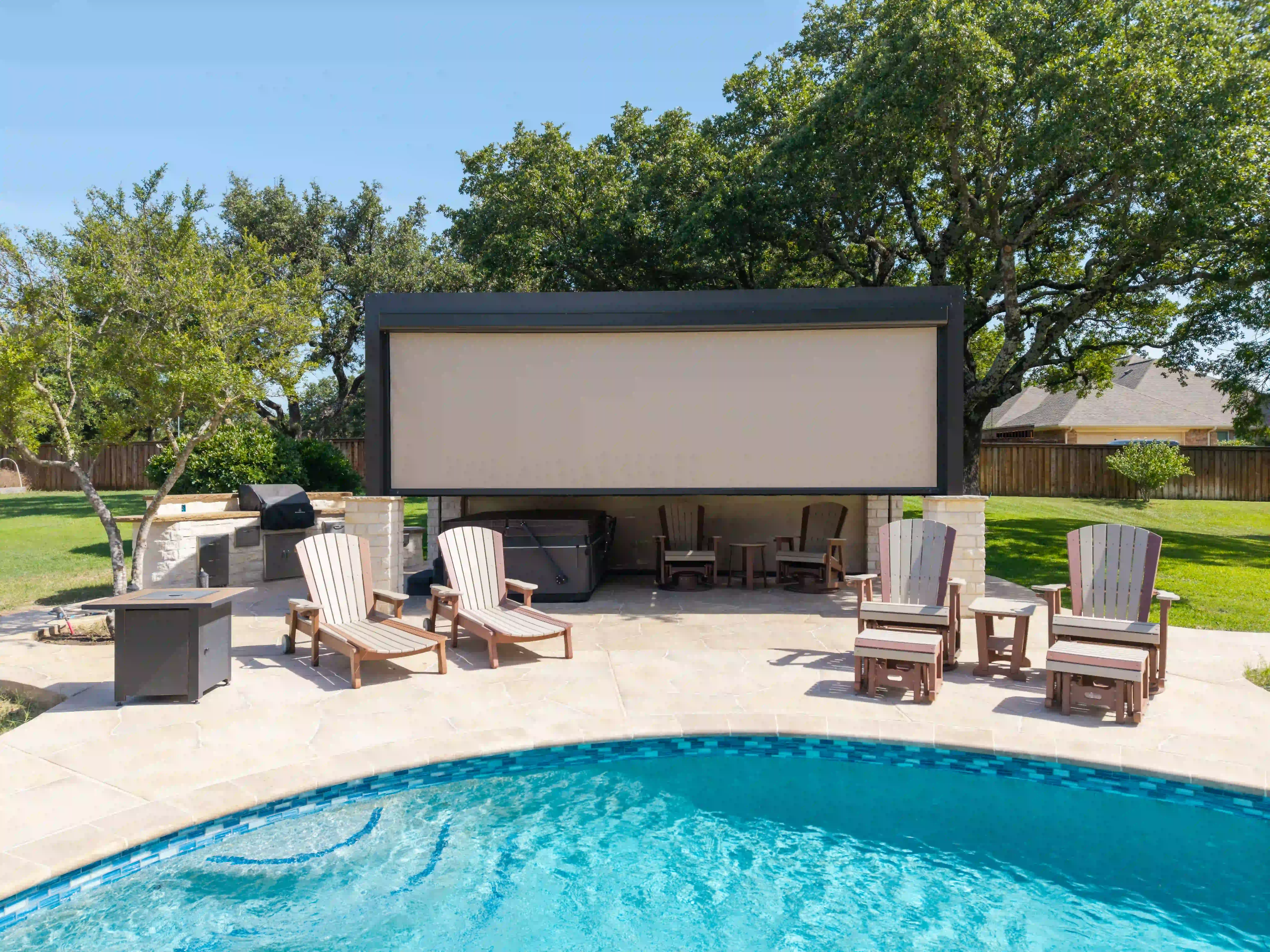 Pool lounge with a full solar-screen wall and a neighboring rooftop beyond the fence
