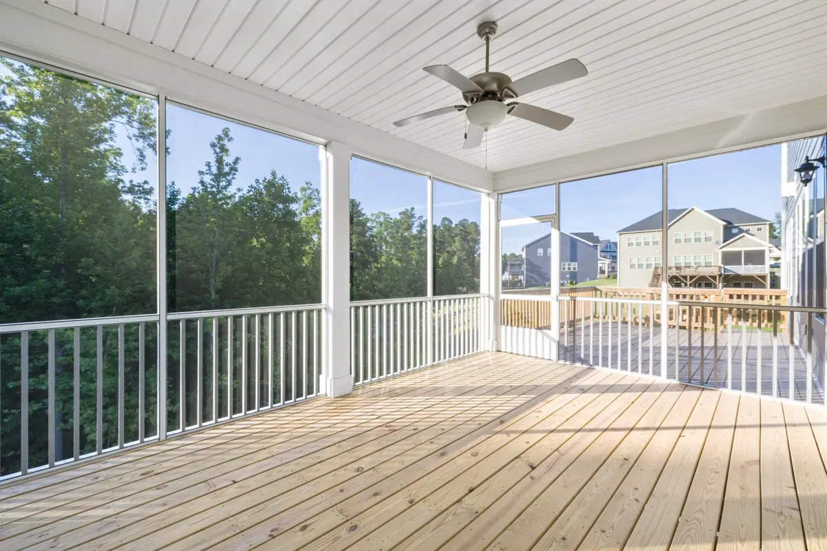 Freshly-built screened deck with unweathered pine decking overlooking a new subdivision