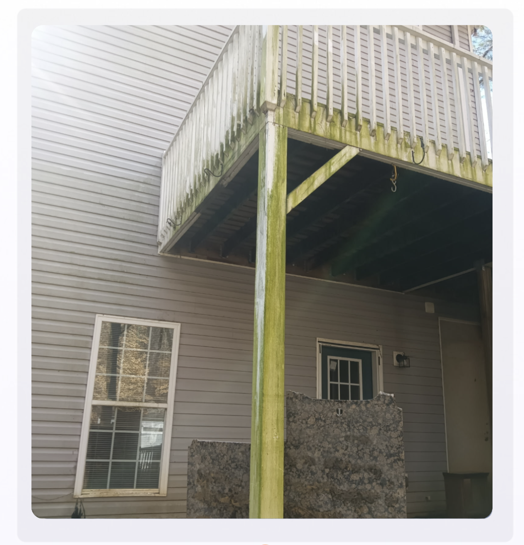 Green algae-covered wood deck before pressure washing in Woodstock GA