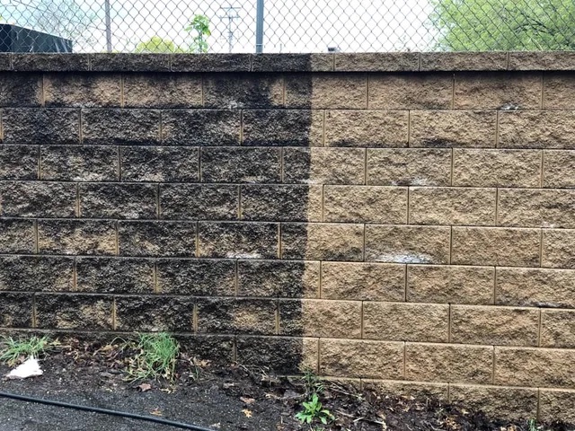Retaining wall before and after pressure washing showing algae and mold removed in Canton GA