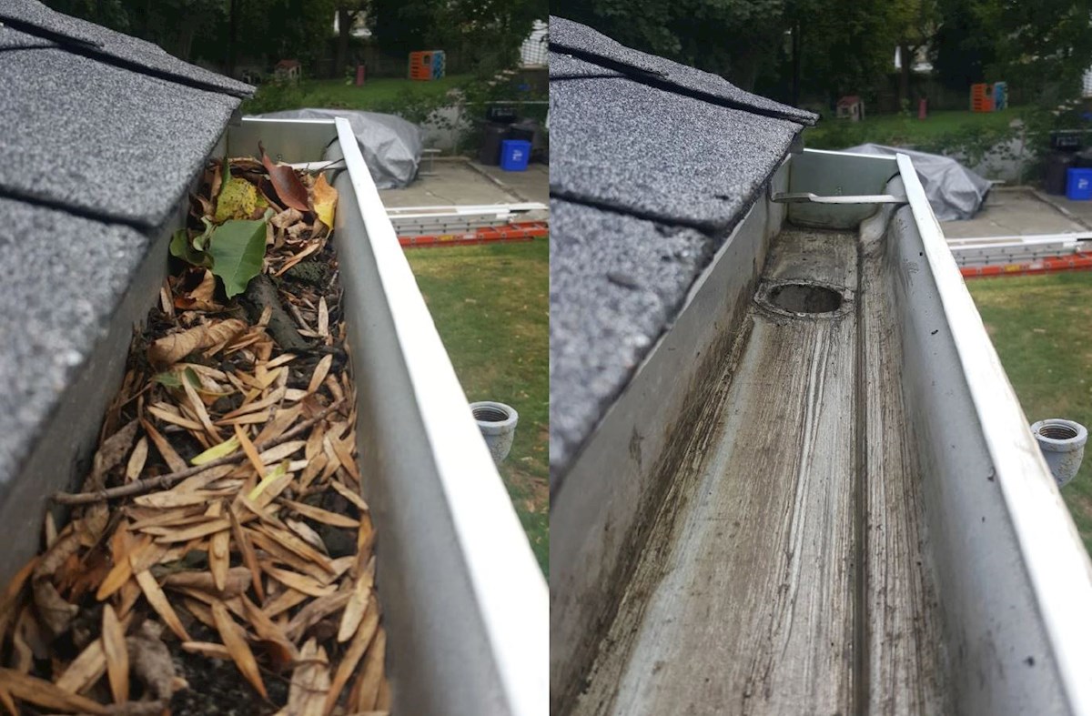 Gutter packed with leaves and sticks before cleaning showing clear downspout after