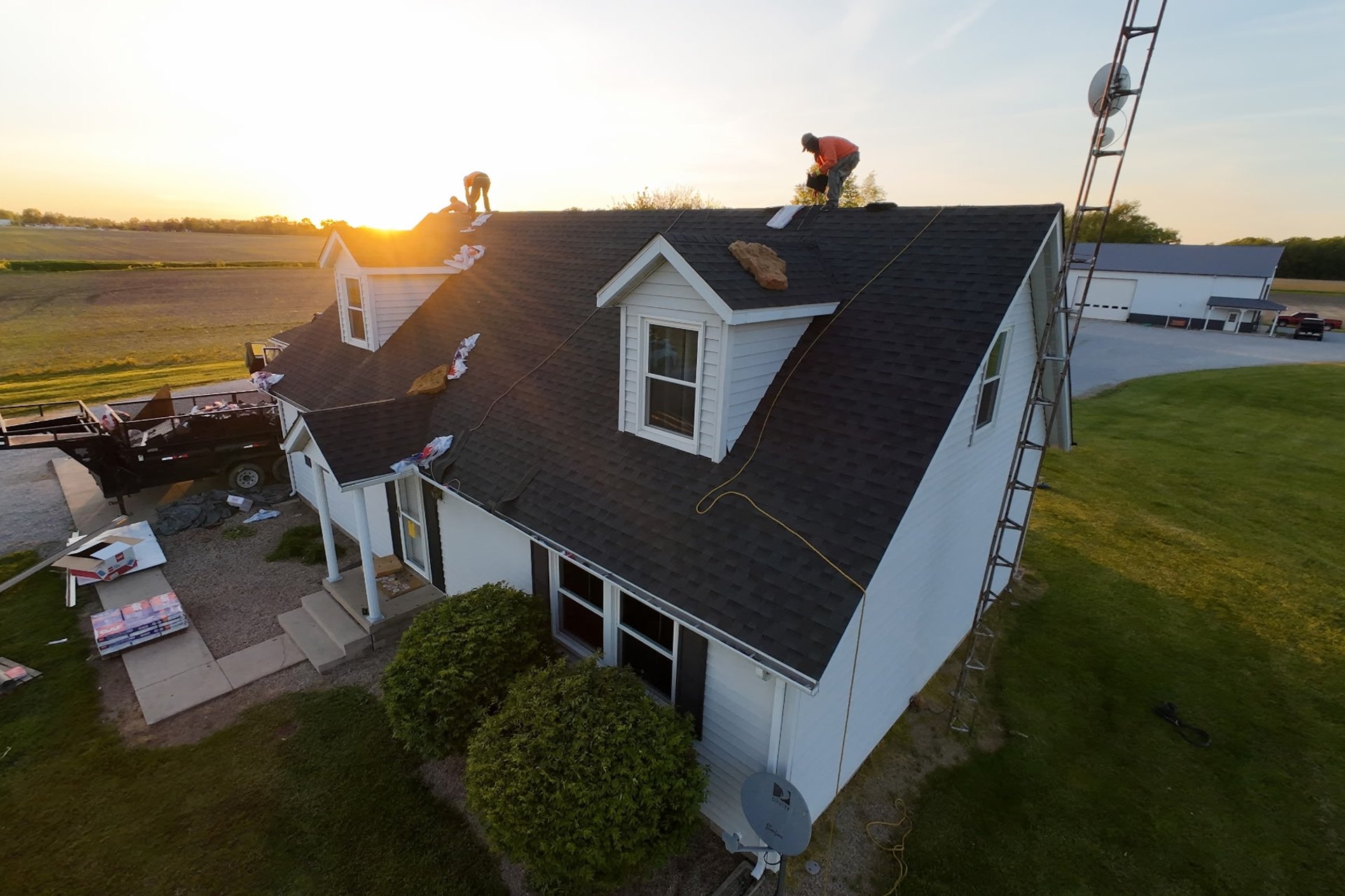 T&C Roofing crew completing a roof at golden hour near Indianapolis