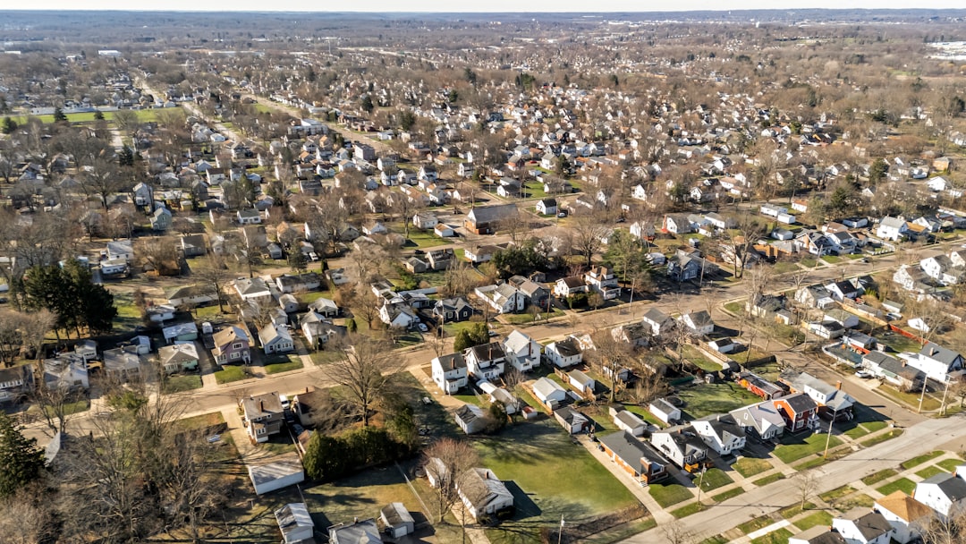 Aerial view of a Midwestern residential neighborhood with modest homes, bare trees and grid streets in late winter.