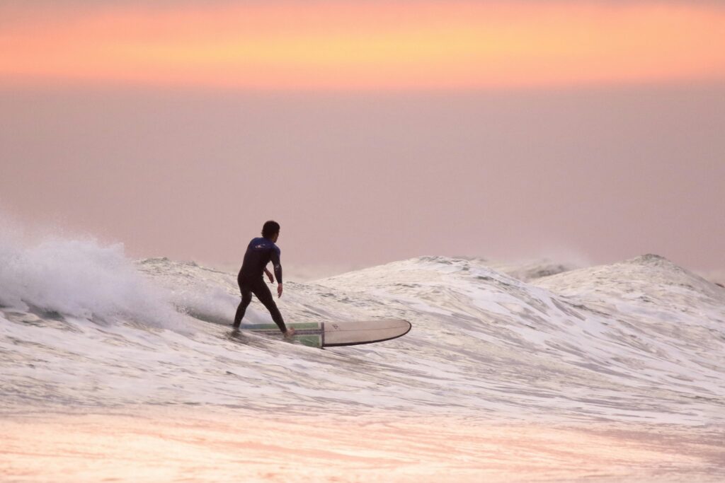 Surfer riding a wave during sunset at the ocean Surfer riding a wave during sunset at the ocean