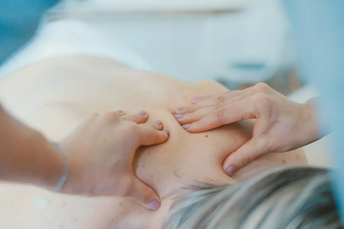 A massage therapist working on a person’s upper back