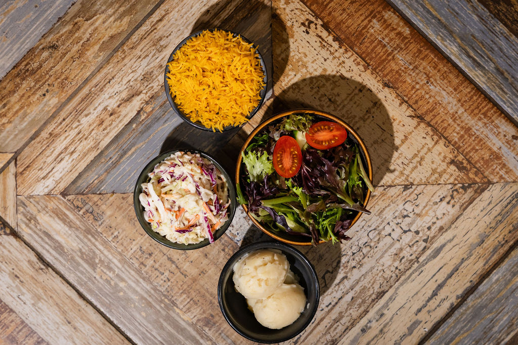 Four peri peri side dishes: rice, salad, mash and coleslaw