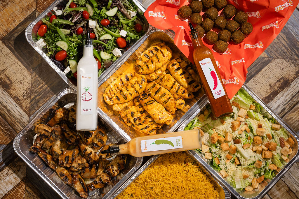 Corporate catering spread with grilled chicken, falafel, and salads