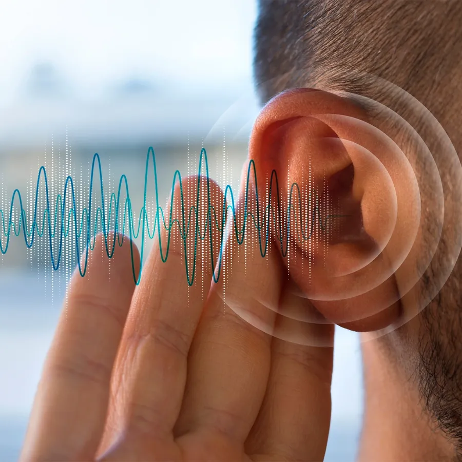 Hombre con la mano detrás de la oreja intentando oír mejor