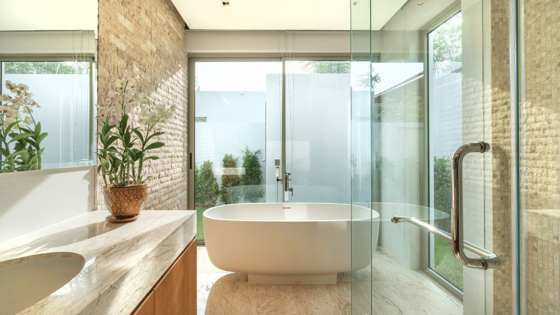 Luxurious bathroom with a freestanding bathtub, glass shower enclosure, and stone-textured walls.