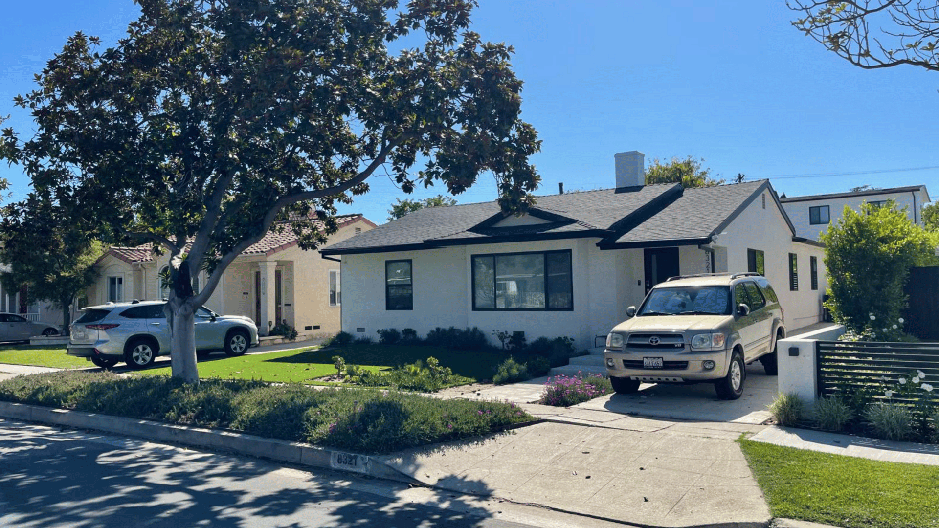 Single-story residential home with a well-maintained lawn, large tree, and driveway.