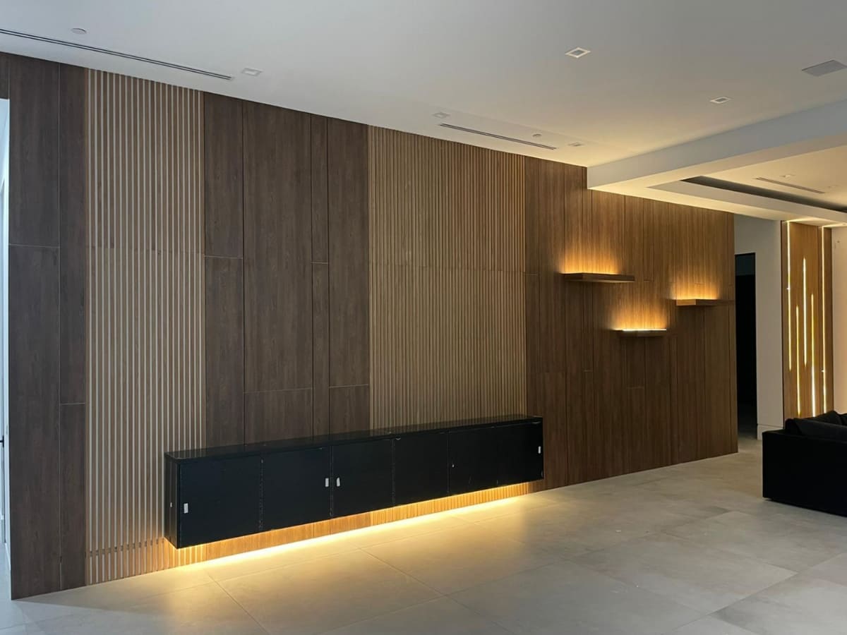 Modern interior with a wood-accented wall, integrated lighting, and minimalist design, creating a warm and inviting atmosphere.