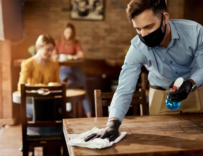 Staff cleaning tables at a cafe