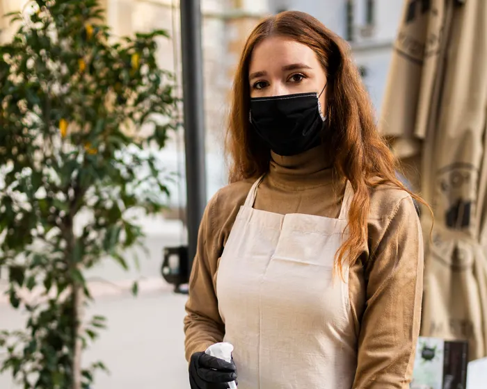 Cleaner disinfecting a coffee shop counter as part of a routine checklist