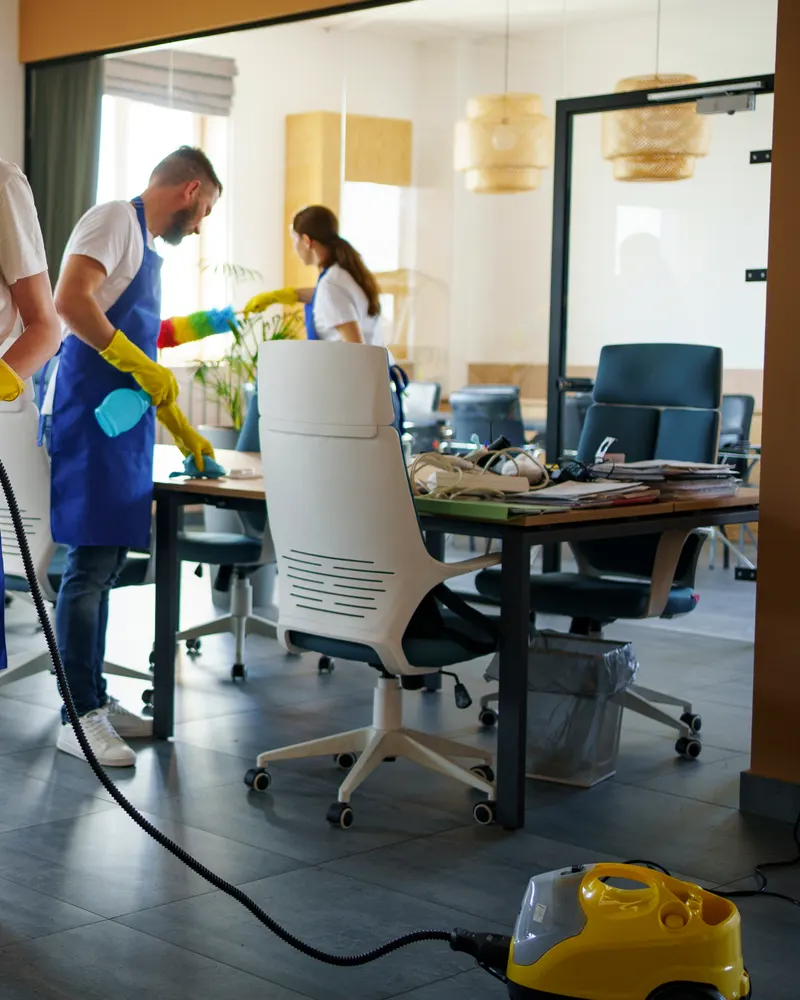 Professional cleaner smiling with cleaning supplies