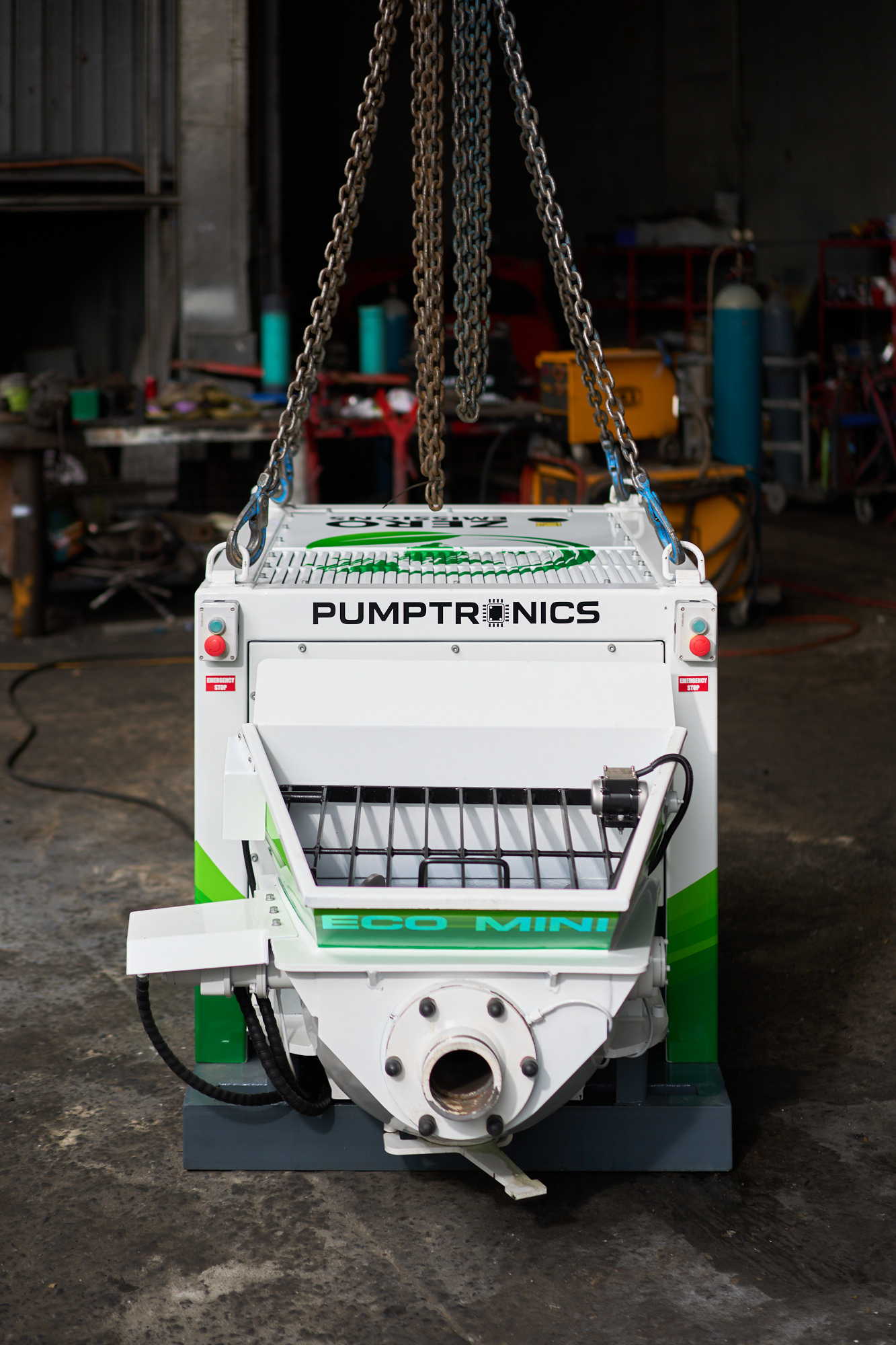 Eco Mini concrete pump hanging from crane chains in the Pumptronics workshop