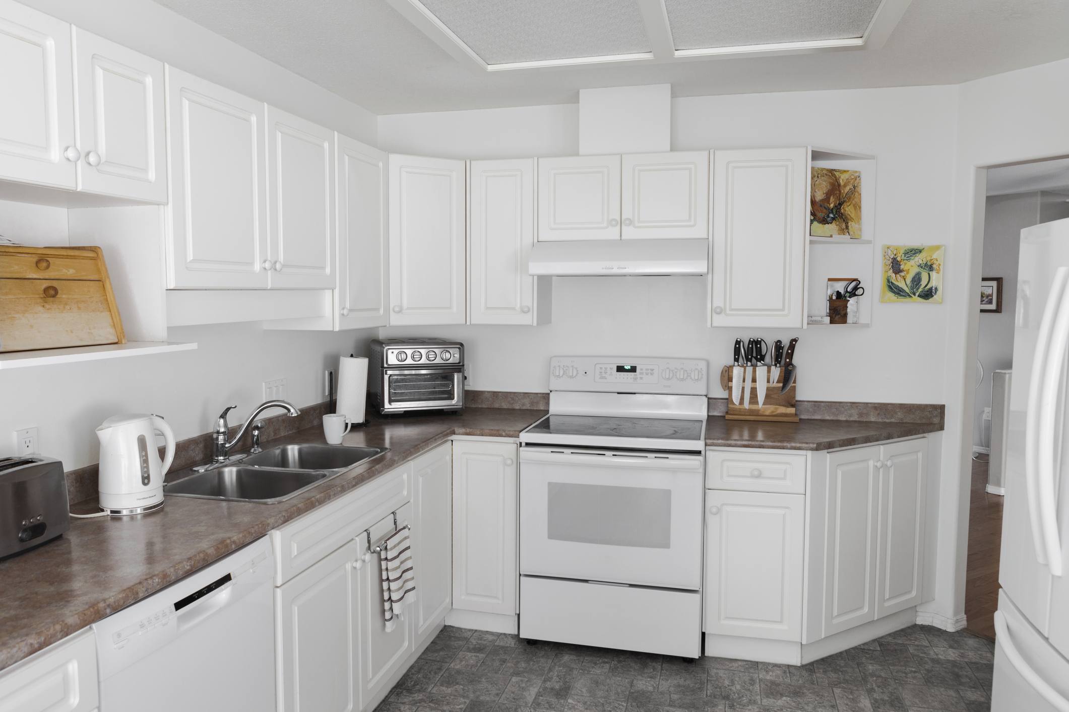 Compact galley kitchen remodel with improved storage and lighting by Cecil Design and Remodel