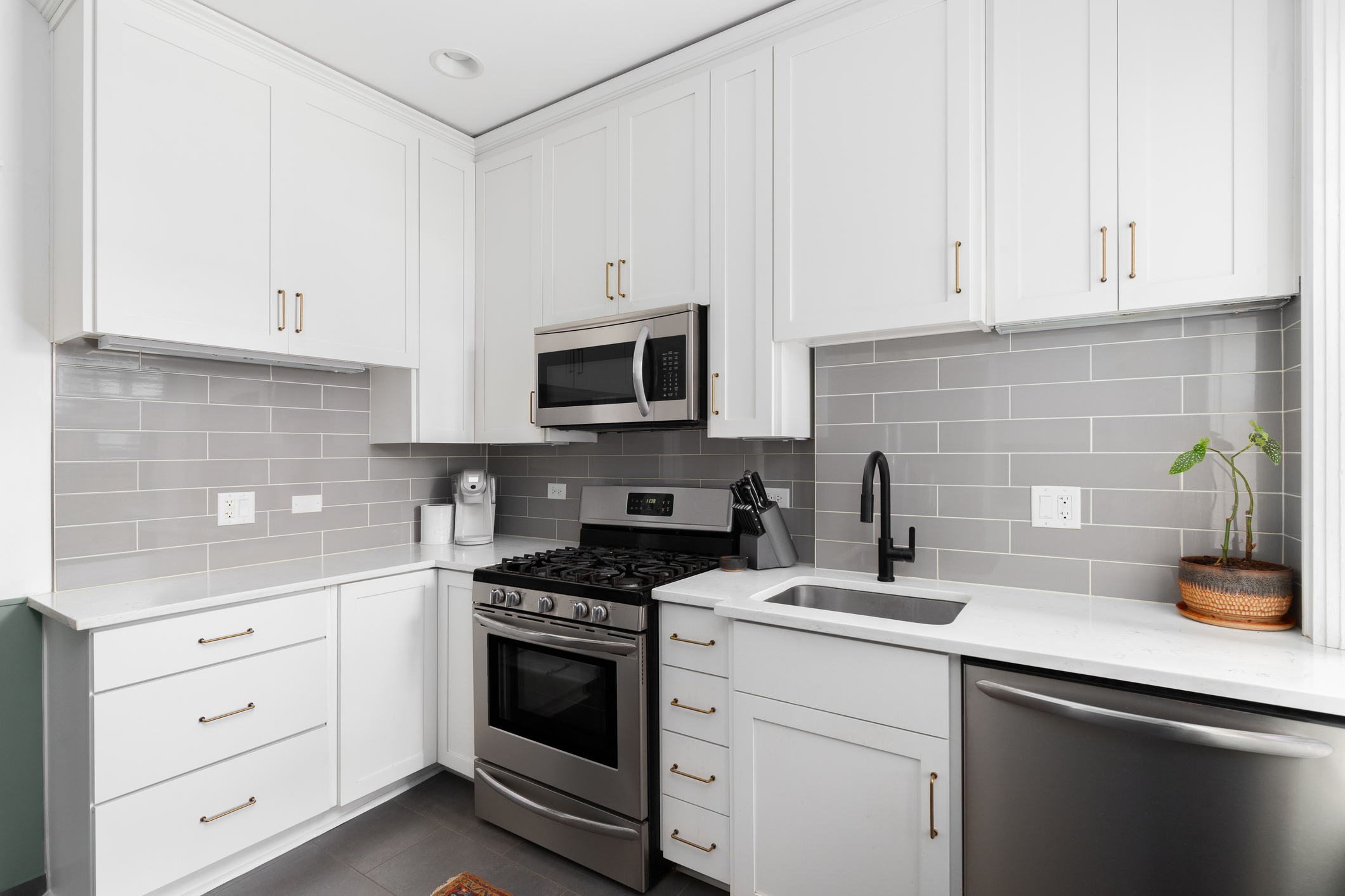 modern kitchen with tile backsplash and white countertops by Cecil Design and Remodel