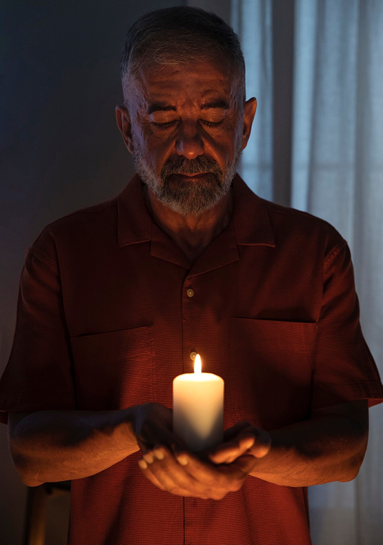 Man holding a candle in quiet reflection