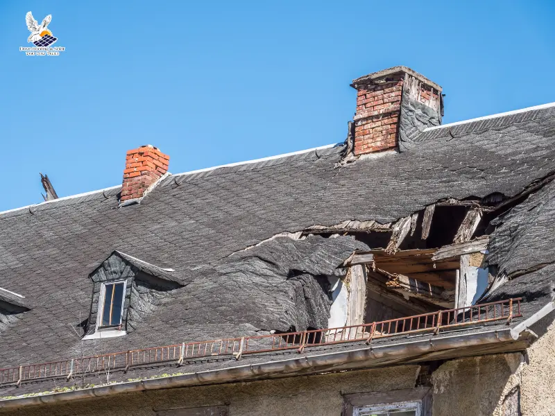 Severely storm damaged roof with exposed rafters and structural collapsed.