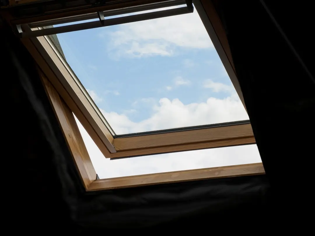 Interior view looking up through an open roof window to the sky