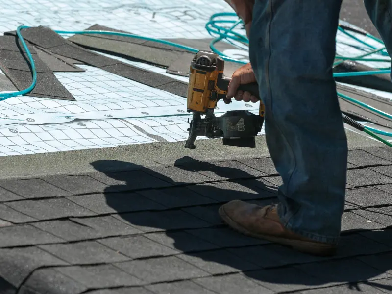 Roofer installing underlayment before a new roof installation in Joshua Tree, CA. Roofer installing underlayment before a new roof installation in Joshua Tree, CA.