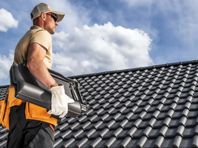 Roofing contractor surveying a completed clay tile roof installation