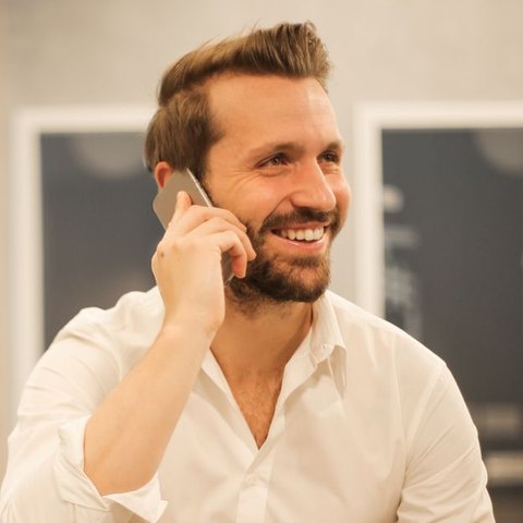 Un propriétaire souriant, au téléphone