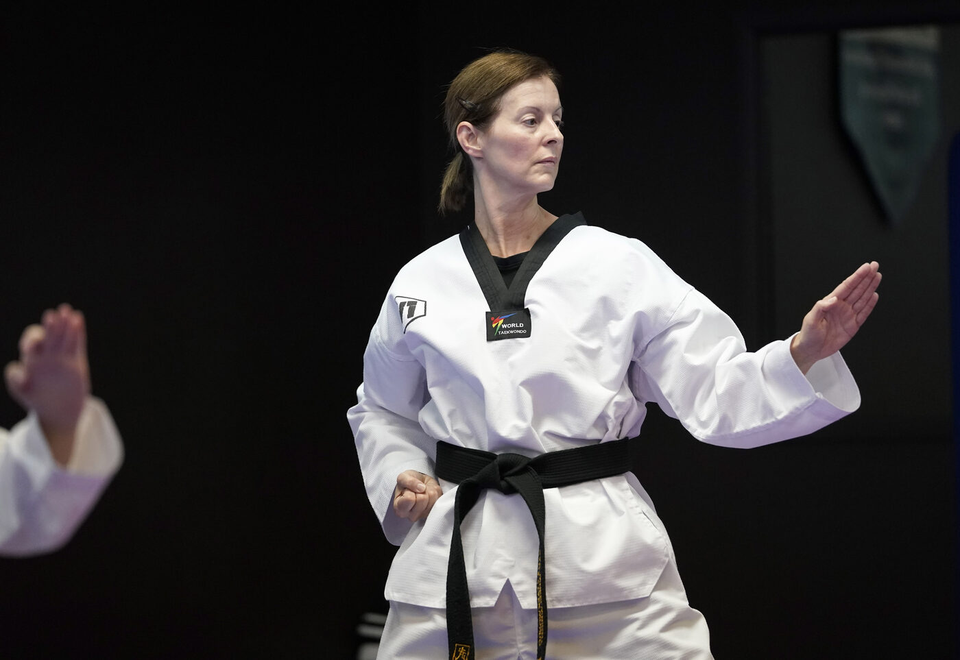 A focused adult black belt mid technique at W1 Taekwondo