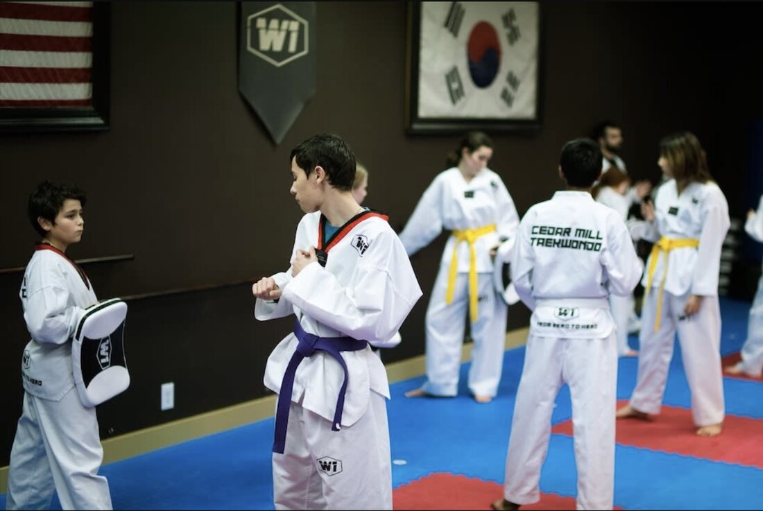 Teen students in formation, focused and adjusting uniform before class at W1 Taekwondo Cedar Mill