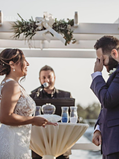 Bride and groom laughing during their ceremony with the officiant behind them
