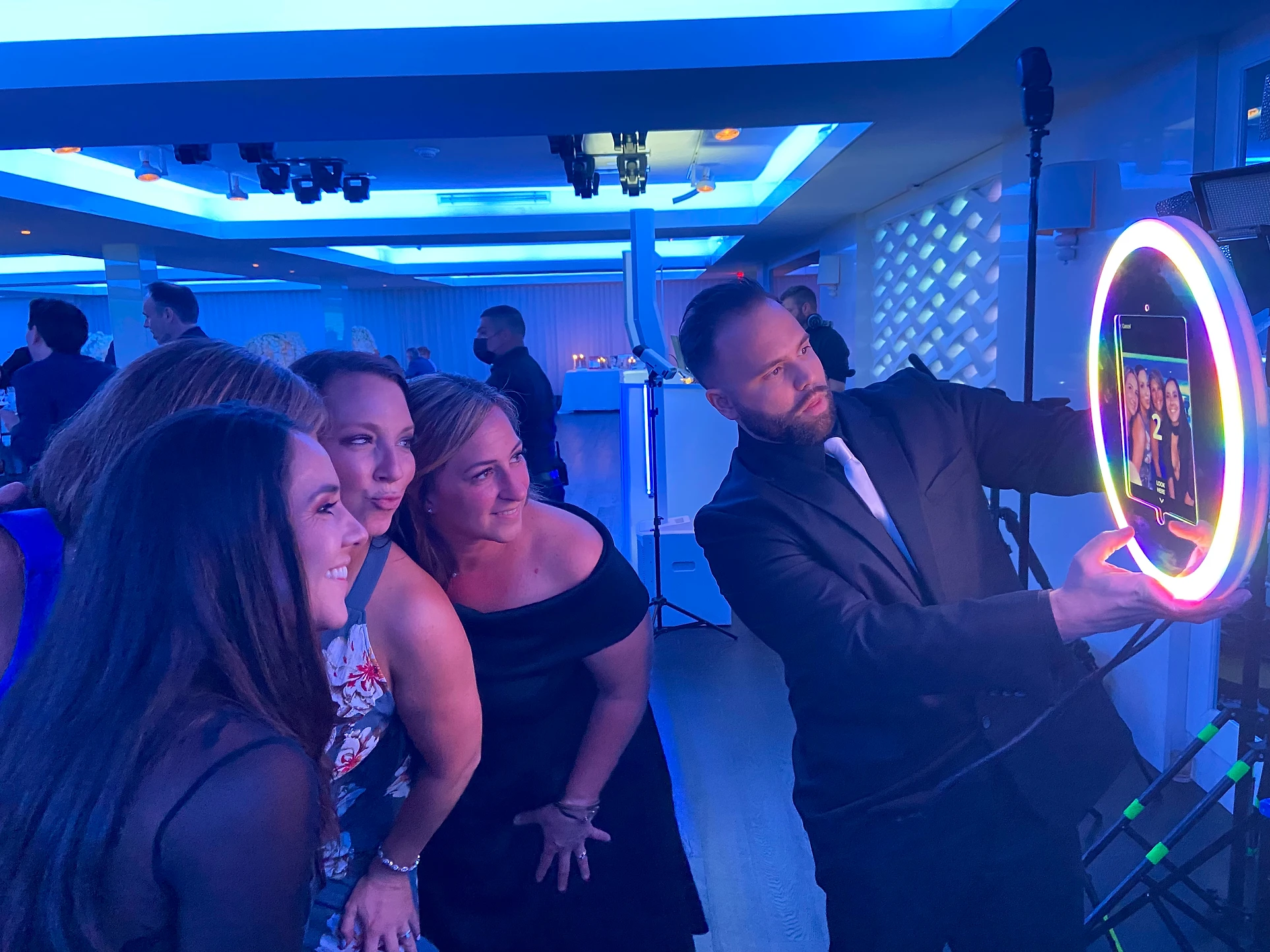 A professional roaming photo booth operator helping guests pose
