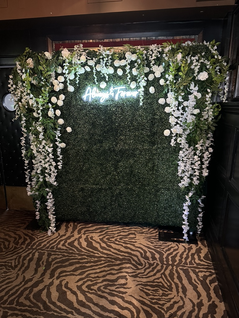 Green and white flower wall photo booth backdrop