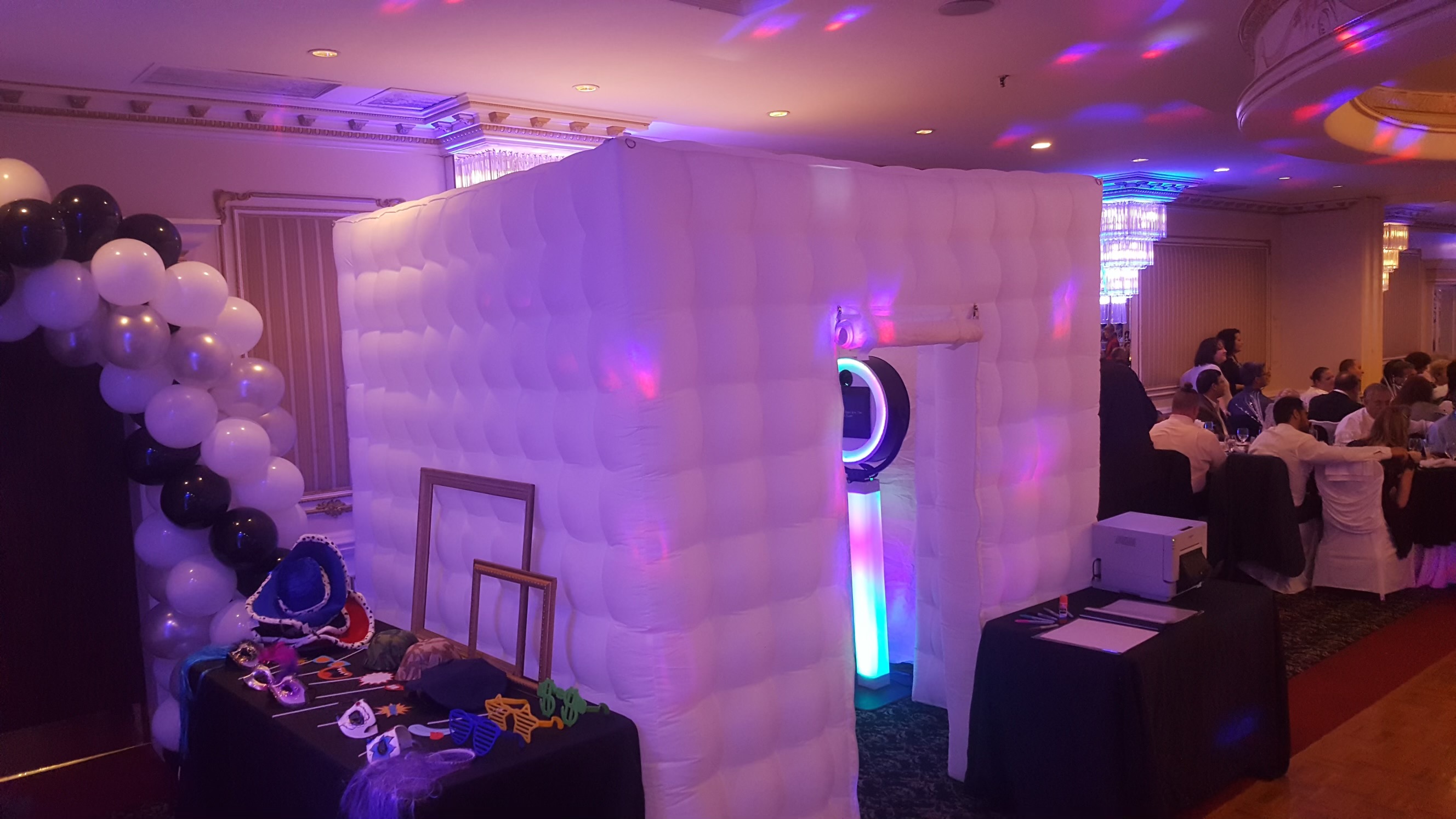 Enclosed photo booth glowing with white and purple lighting