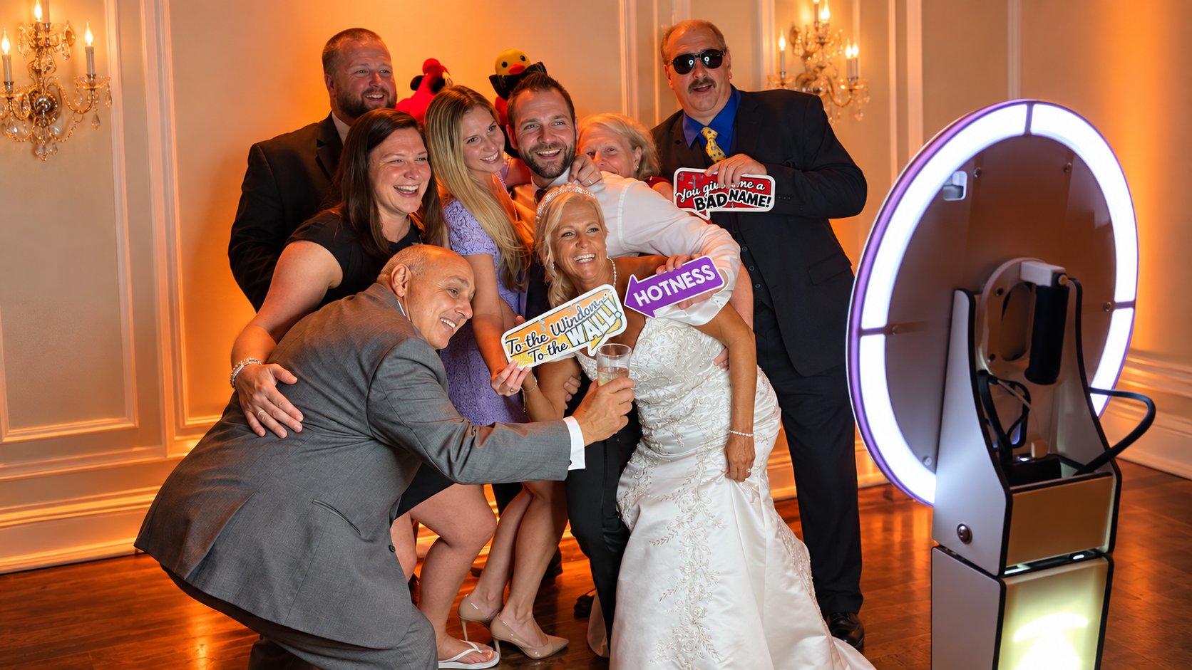 Wedding party posing with props at a ring light photo booth
