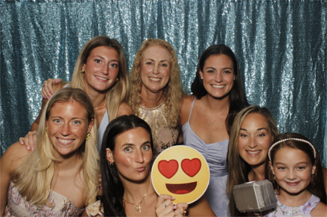 Friends with props in front of a teal sequin backdrop