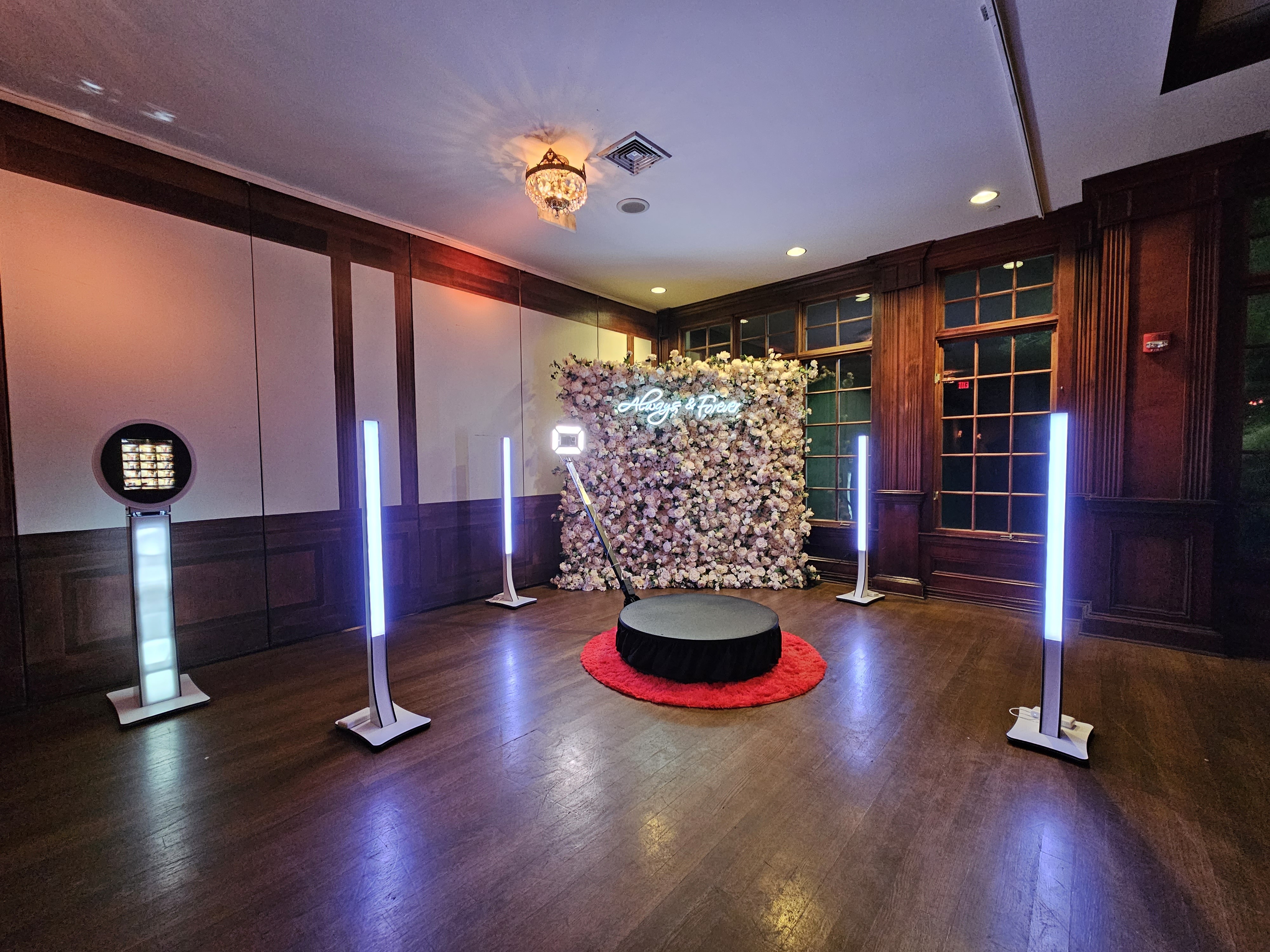 360 video booth with LED pillars in front of a flower wall