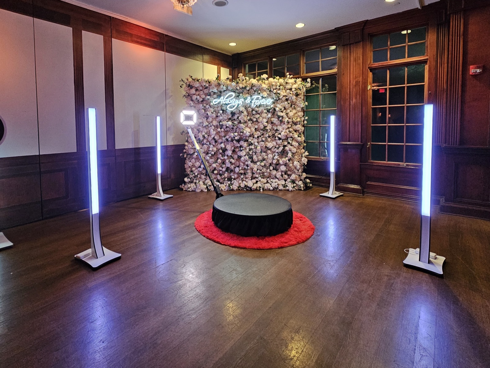 360 video booth with LED pillars in front of a flower wall