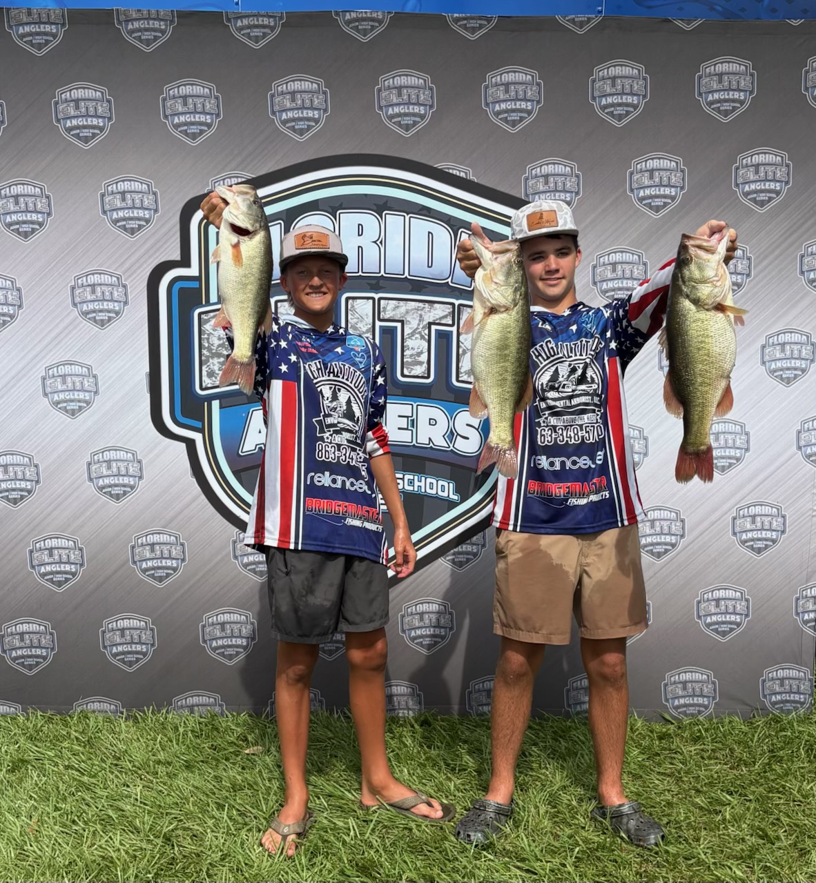  Mac Swain and Lane Hermelbracht holding their fish in front of the large FEA backdrop.