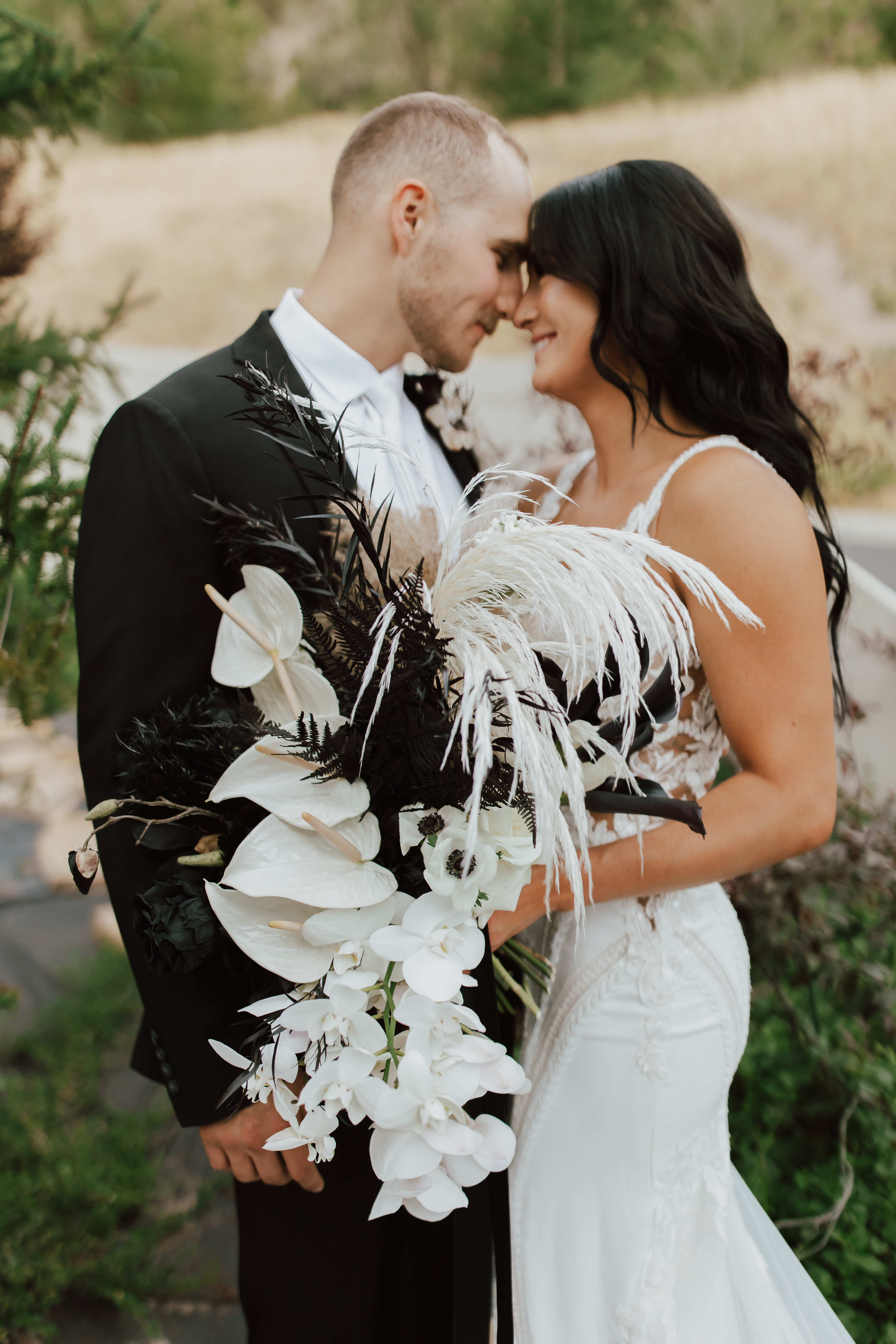 Groom and bride with a sculptural white bouquet