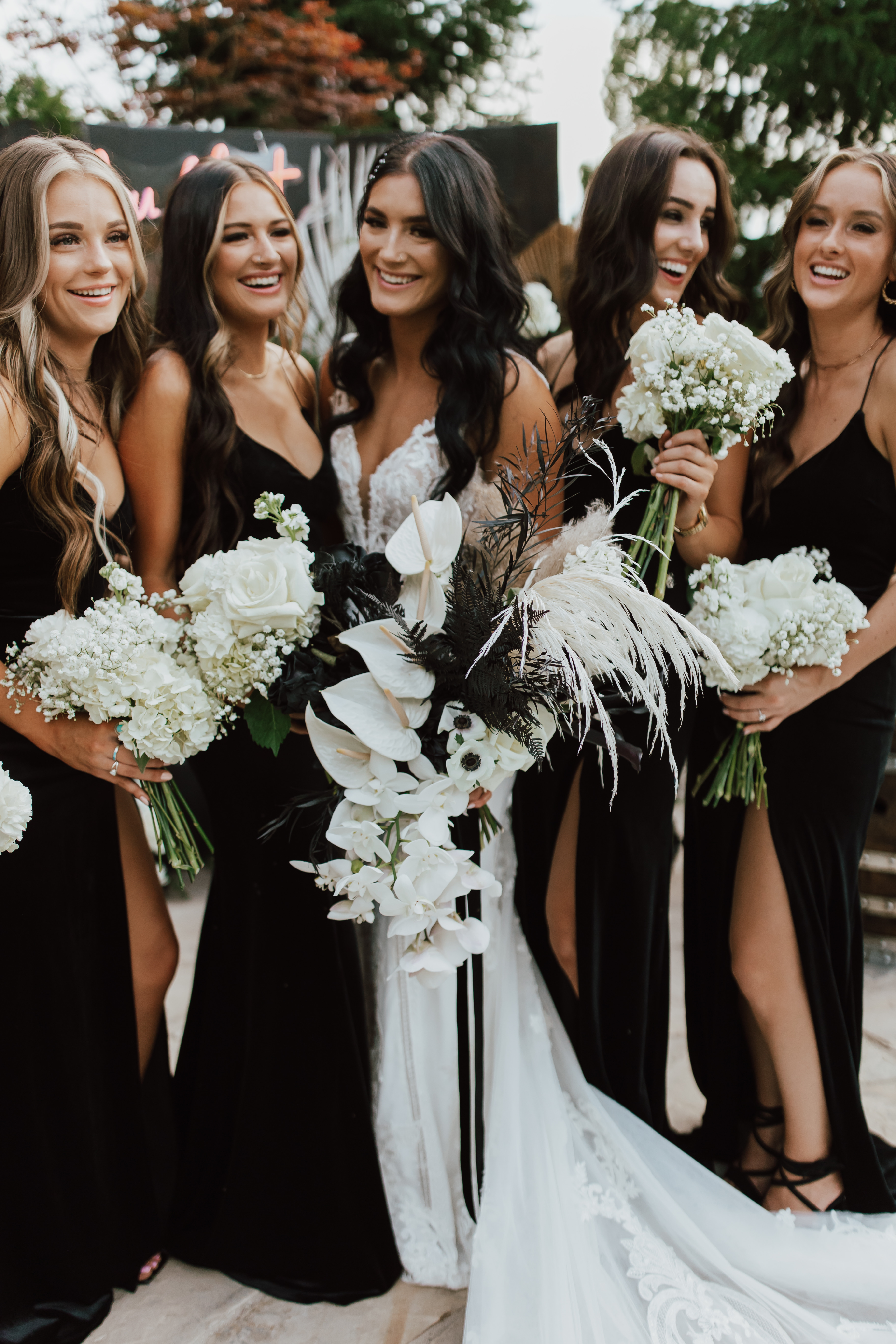 Bridesmaids in black holding ivory bouquets