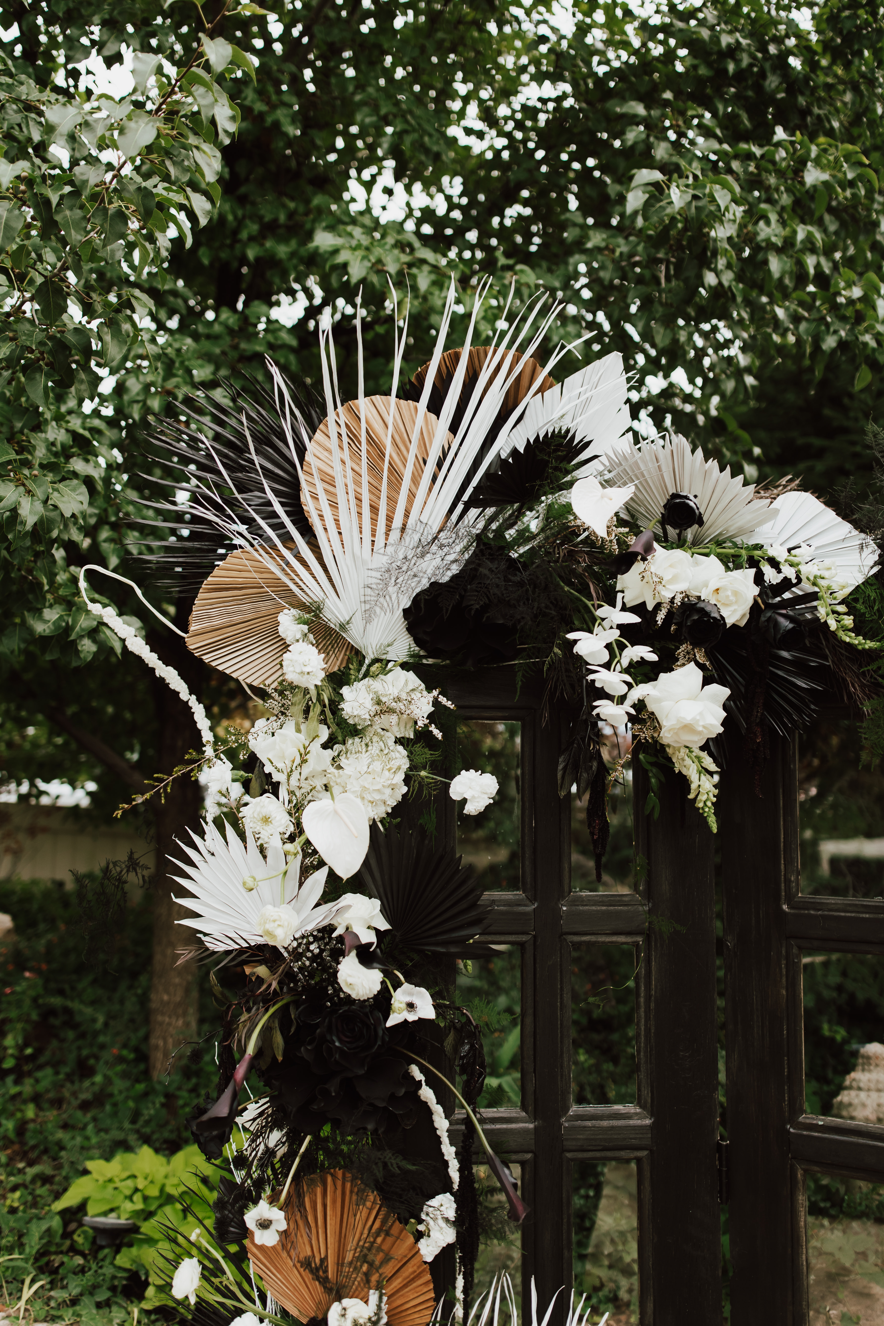 Dried palm and floral installation with dark accents