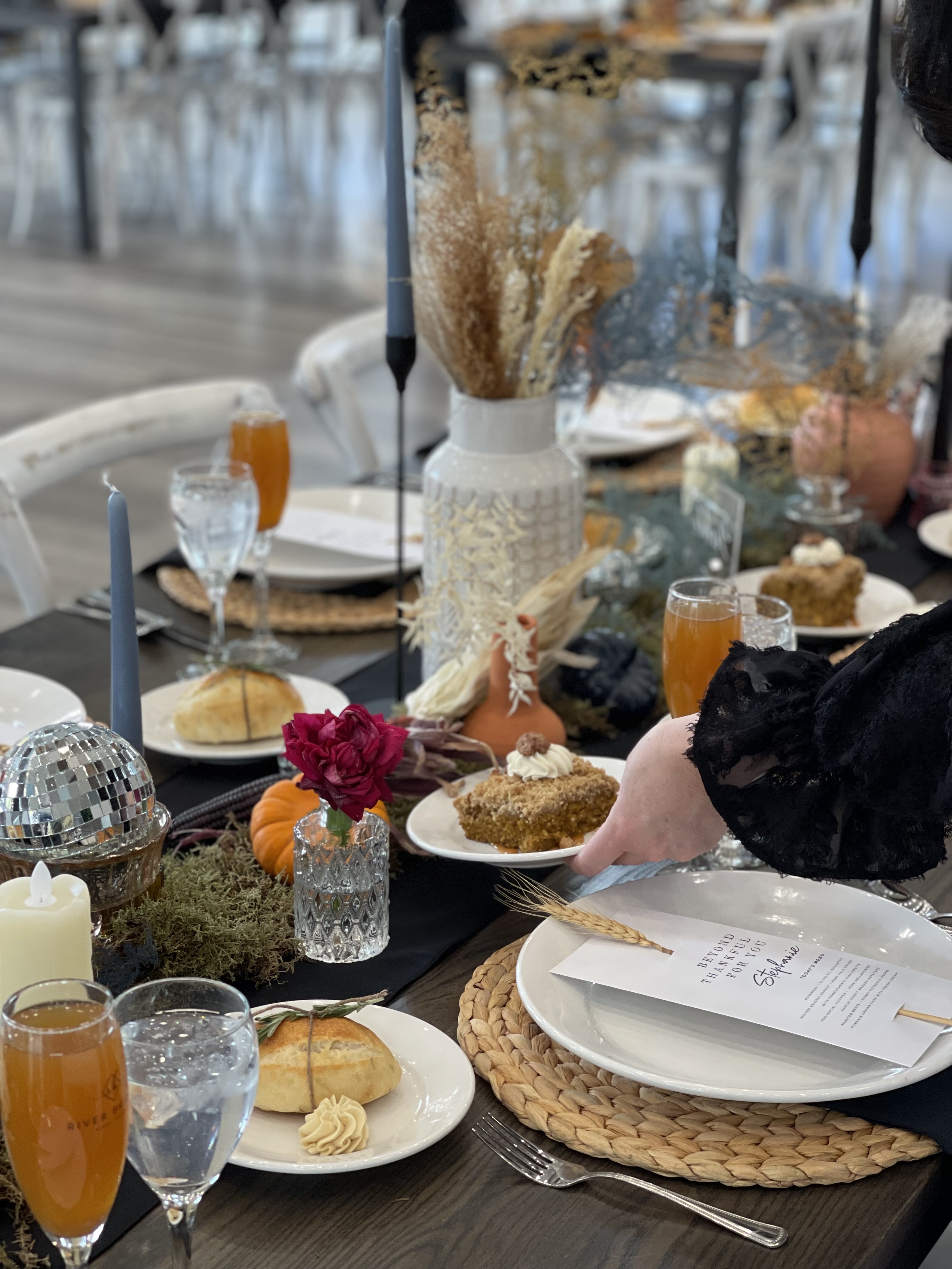 Styled dinner table with dried pampas, candles, and jewel-toned florals for a private event