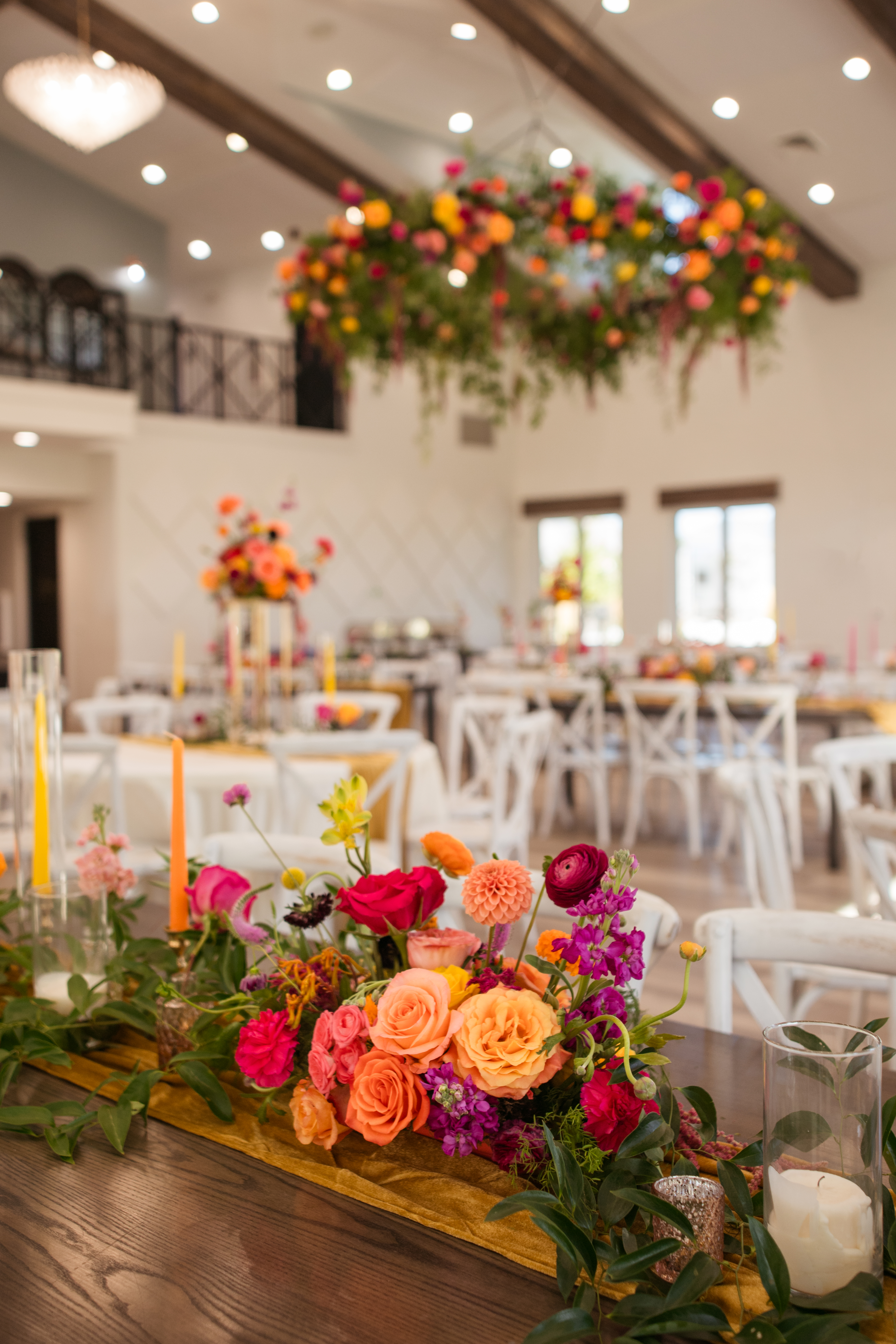 Reception hall with suspended florals and bright centerpieces