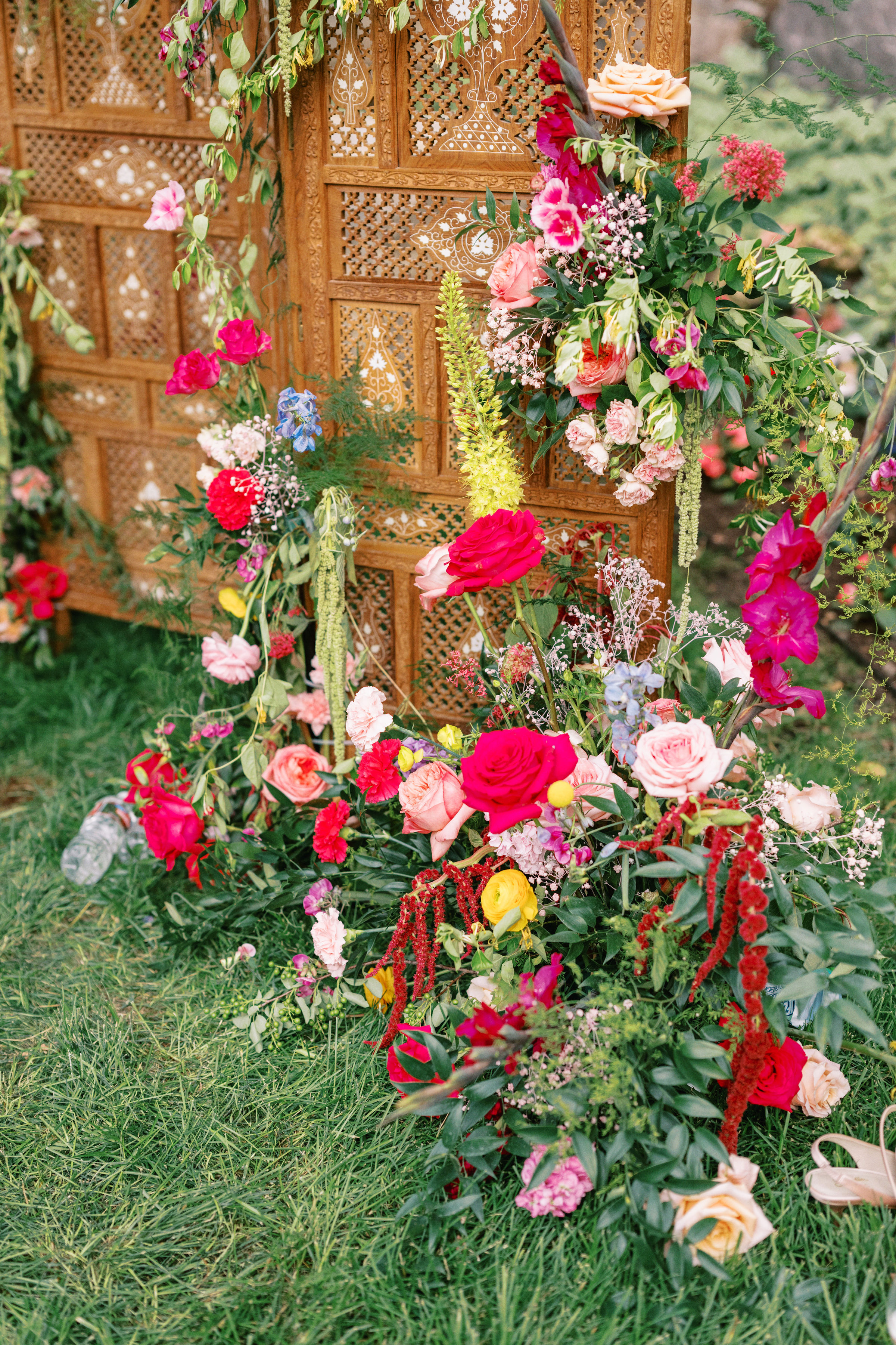 Lush floral installation framing a carved wooden screen