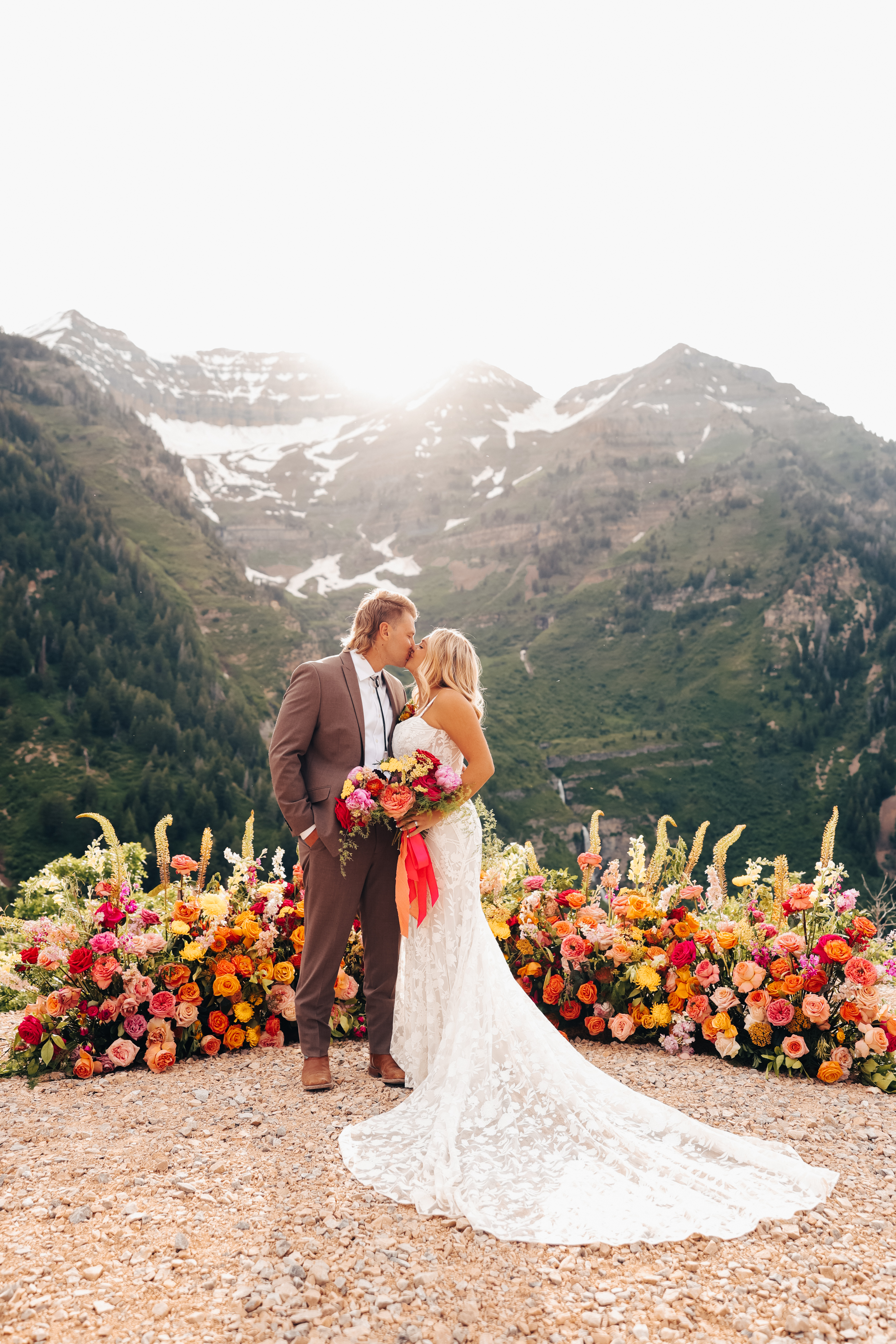 Bride and groom at a colorful ceremony meadow with mountain views