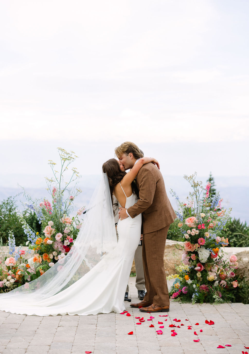 Bride and groom embracing beside a mountain ceremony meadow at Snowbasin