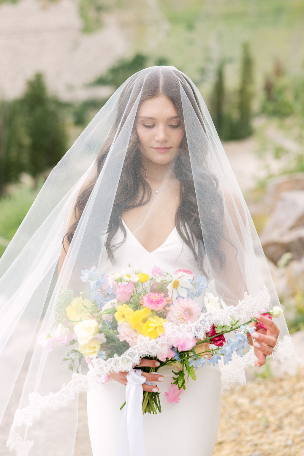 Veiled bride holding a bright garden bouquet