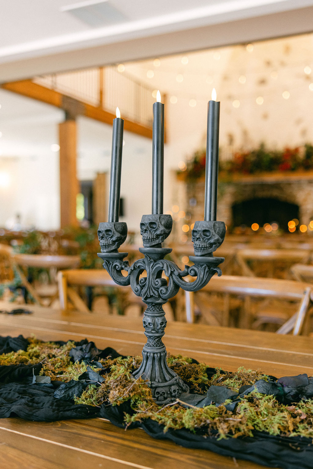 Black candelabra on a moss-covered reception table